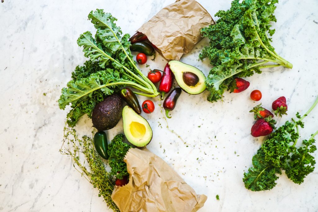 vegetables and some strawberries on a white marble counter top, spilling from a brown bag. All are keto friendly. 
Photo by Wendy Wei from Pexels
