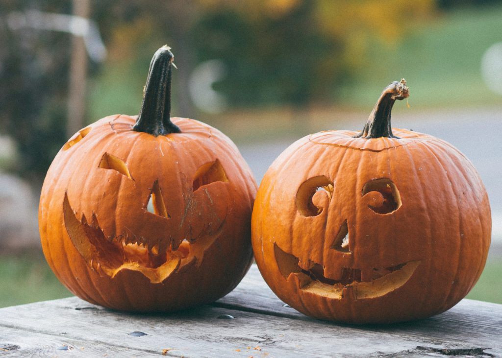 Two orange pumpkins that have been carved for Halloween.