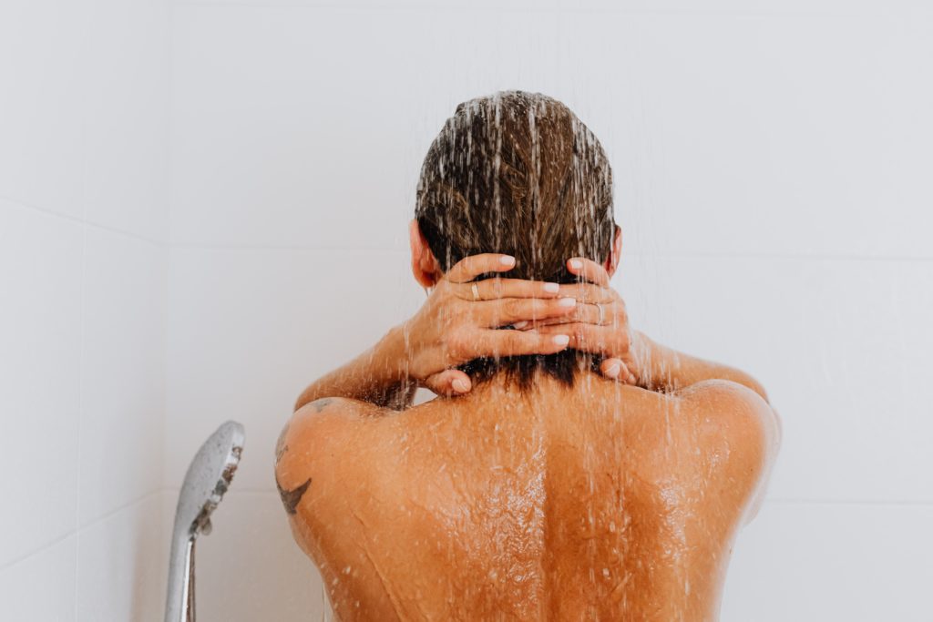 Woman taking a cold shower.