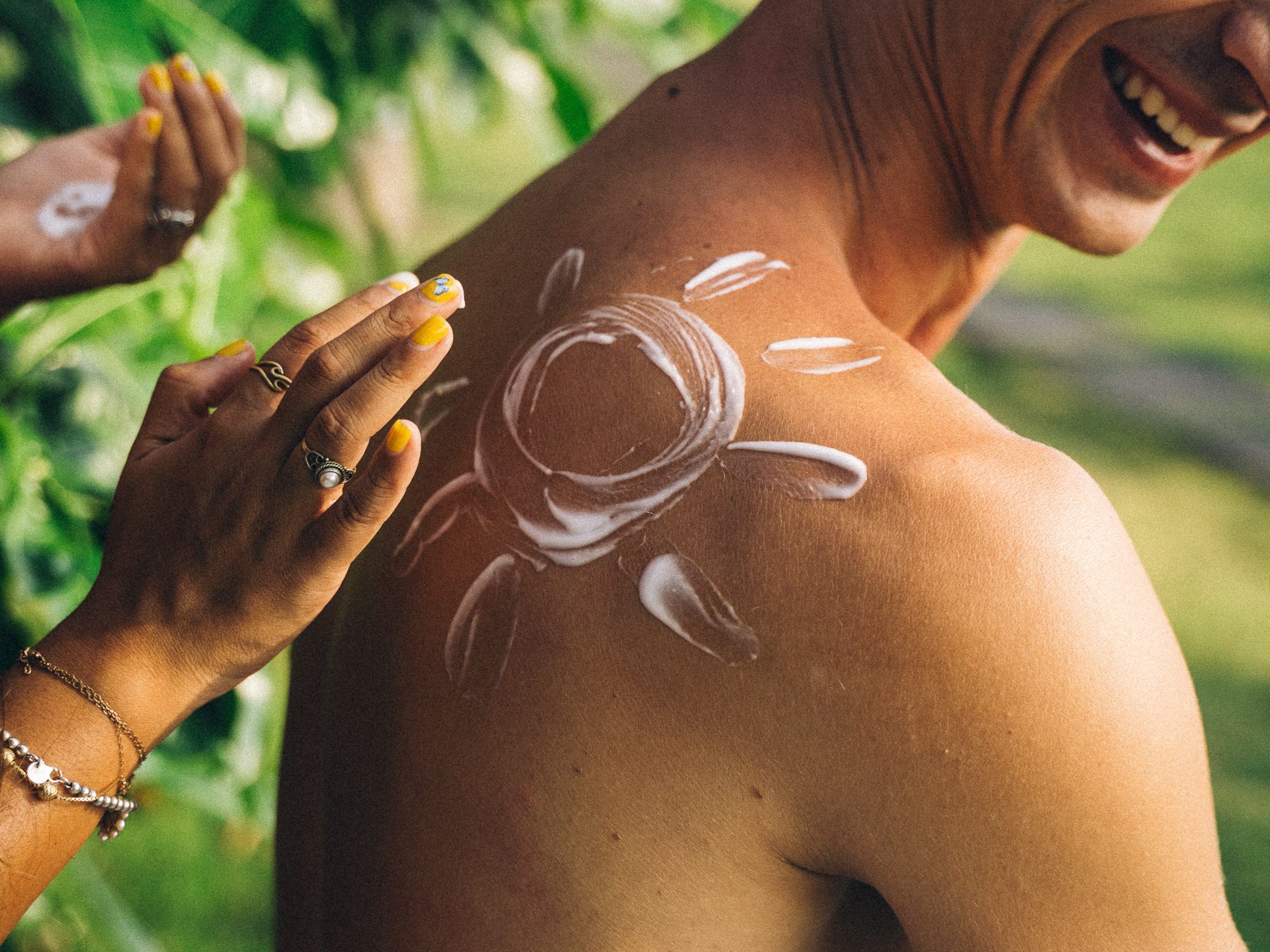 Person applying sunscreen on someone's back