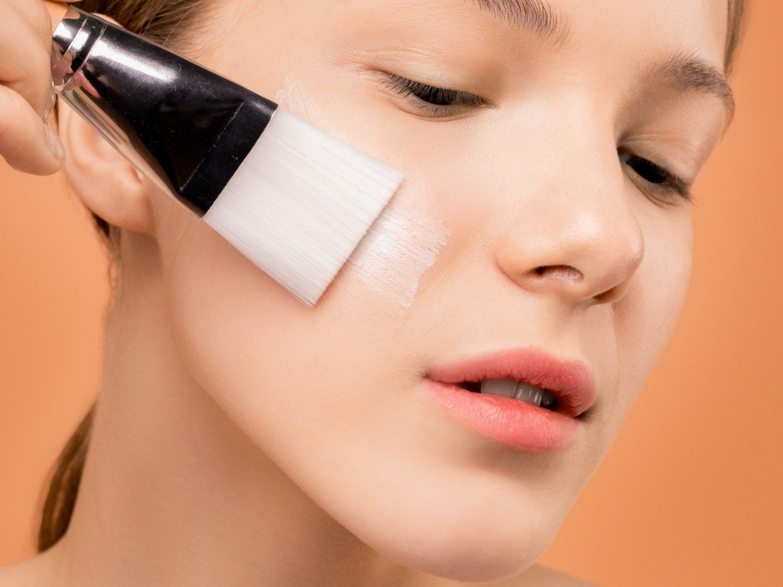 Person applying a mask to reduce pore appearance 