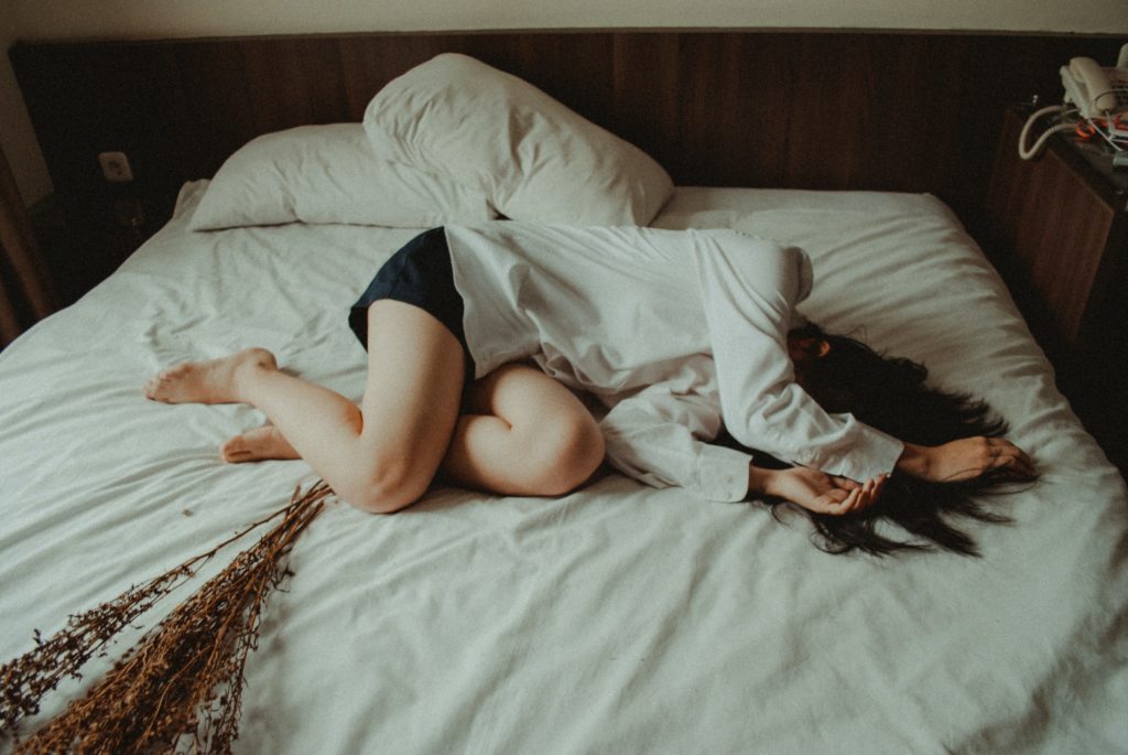 Woman lying in bed, depressed.