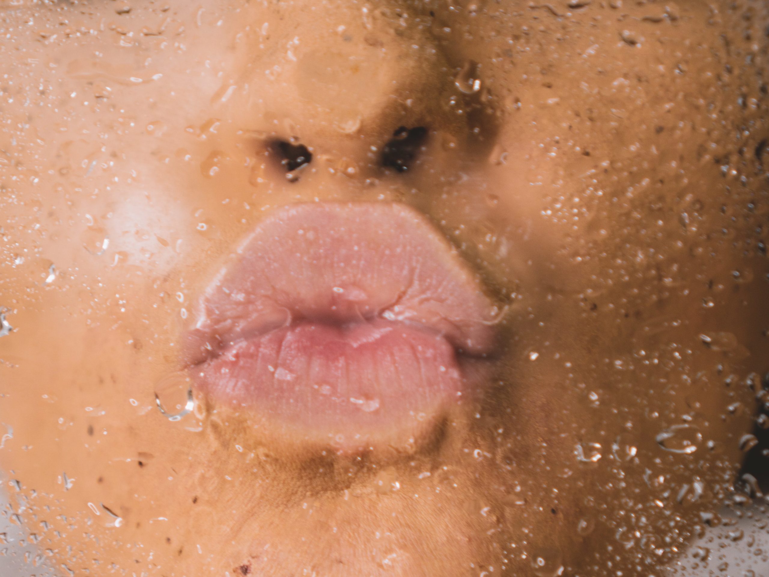 person pressing dry lips on a wet glass