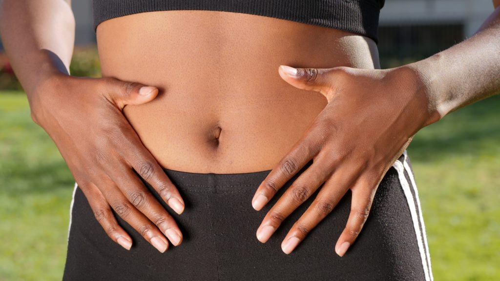 person holding their stomach, where the gut microbiota is.