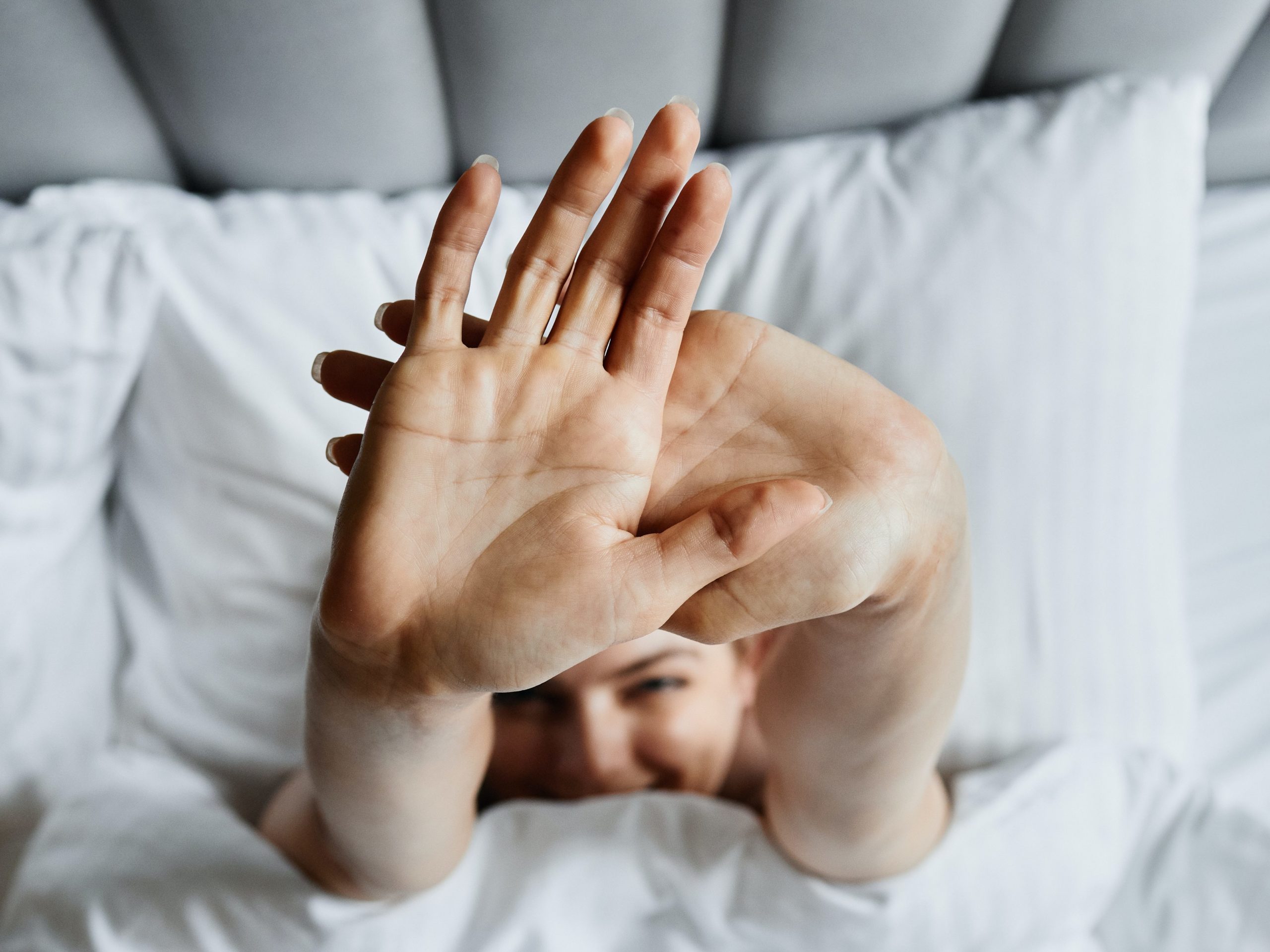 person in bed stretching