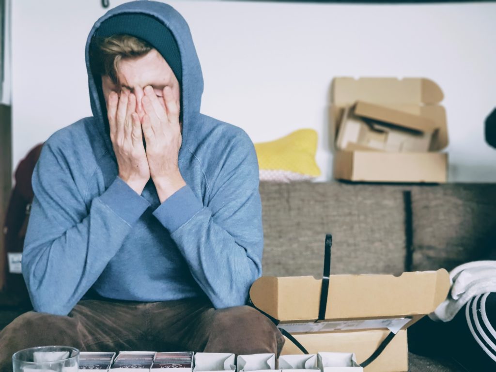 man coving his face feeling burnout