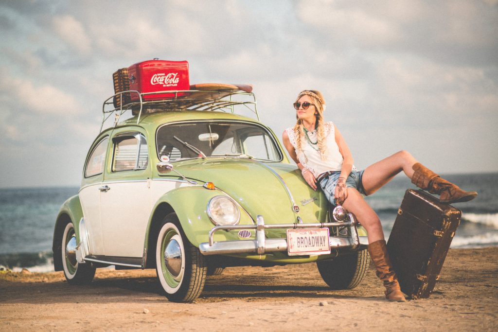 image of someone by a classic car, romanticize the summer with a trip