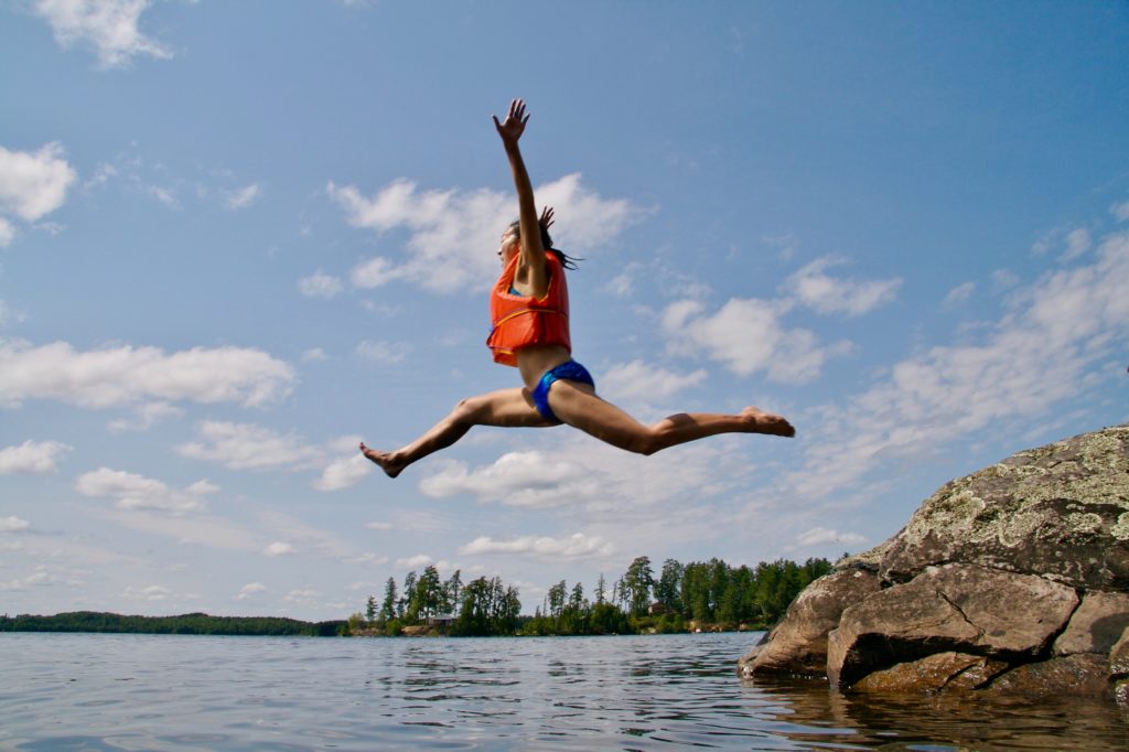 image of someone jumping into a lake as an activity to romanticize the summer