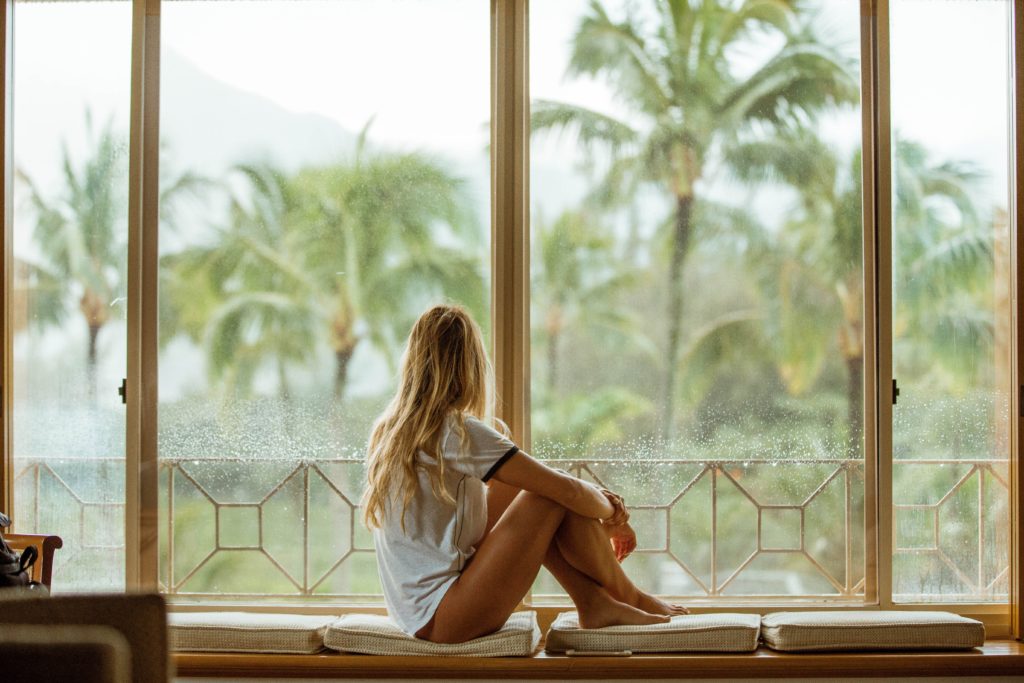 image of a person by the window for selfcare romanticize the summer