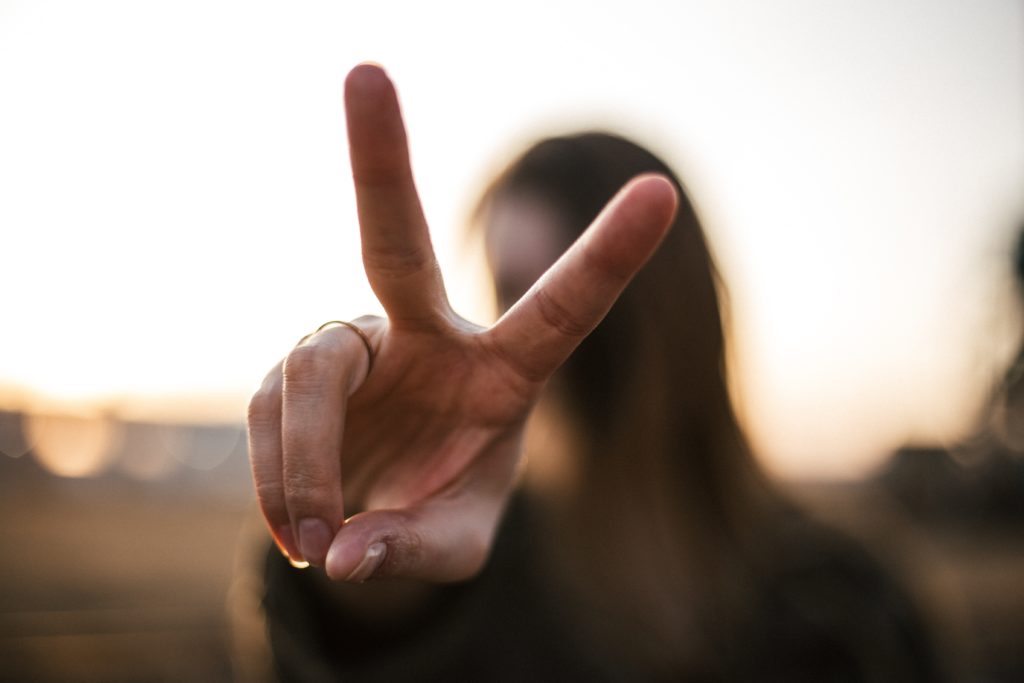 person holding up peace sign