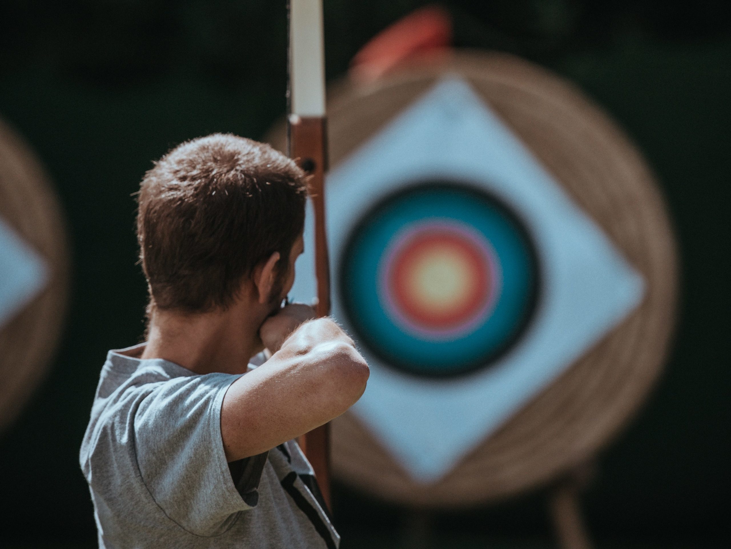 person with bow and arrow aiming for a target, staying calm under pressure